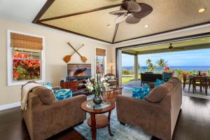 a living room with two chairs and a living room with a view at Holua Kai 21 in Kailua-Kona