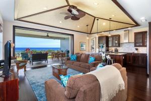 a living room with couches and a kitchen with a view at Holua Kai 21 in Kailua-Kona +43 photos