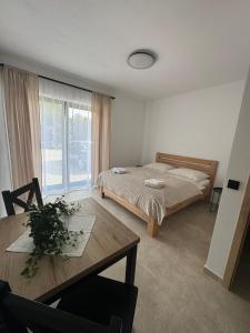 a bedroom with a bed and a table and a window at Penzion Mlýn Cibotín in Česká Bělá
