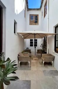 a patio with couches and a large umbrella at Casa Antik in Loja
