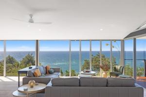 a living room with a couch and a view of the ocean at Sandcastle by Coast Hosting in Wamberal