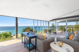 a living room with a view of the ocean at Sandcastle by Coast Hosting in Wamberal