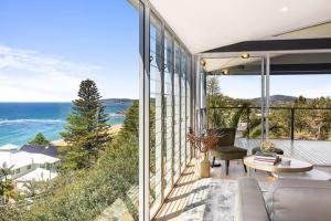 a living room with a view of the ocean at Sandcastle by Coast Hosting in Wamberal