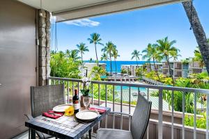 a table and chairs on a balcony with a view of the ocean at Alii Villas 309 in Kailua-Kona