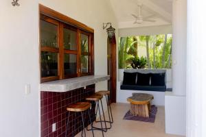 a kitchen with a bar with stools and a window at Villas Carrizalillo in Puerto Escondido