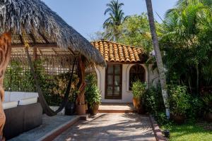 a house with a swing and a palm tree at Villas Carrizalillo in Puerto Escondido