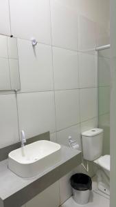 a white bathroom with a sink and a toilet at Villas Hotel in Barreiras