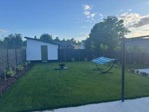 a yard with a blue swing in the grass at Dom Okale in Kazimierz Dolny