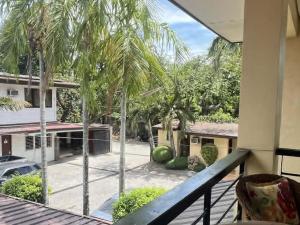 a balcony with a view of a yard with palm trees at 11th Street Bed and Breakfast in Bacolod