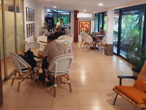 a group of people sitting at a table in a restaurant at 11th Street Bed and Breakfast in Bacolod