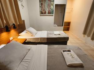 a room with two beds and a tv in it at 11th Street Bed and Breakfast in Bacolod