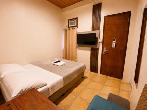 a hotel room with a bed and a television at 11th Street Bed and Breakfast in Bacolod +40 photos