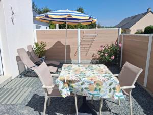 a table and chairs with an umbrella on a patio at Studio cosy in Granville