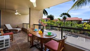 a patio with a table and chairs on a balcony at Kona Pacific C520. in Kailua-Kona