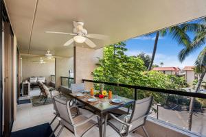a dining room with a table and chairs on a balcony at Kona Pacific D622 in Kailua-Kona
