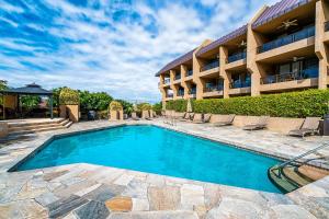 a swimming pool in front of a hotel at Kona Pacific D622 in Kailua-Kona