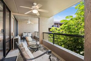 a balcony with chairs and a ceiling fan at Kona Pacific D622 in Kailua-Kona +29 photos