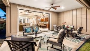 a patio with chairs and tables and a living room at Holua Kai 6 in Kailua-Kona