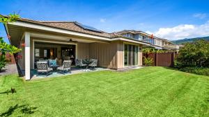 a house with a yard with green grass at Holua Kai 6 in Kailua-Kona