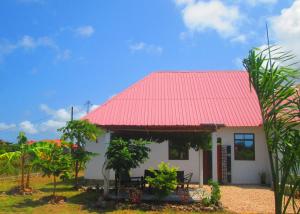 a small white house with a red roof at Maku House in Makunduchi