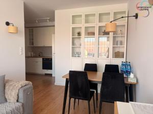 a kitchen and dining room with a table and chairs at Apartament Olimpia in Lębork