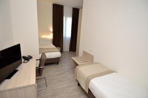 a hotel room with two beds and a flat screen tv at Hotel Nuova Mestre in Mestre