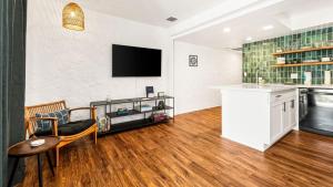 a living room with a television on a wall at Casa de Emdeko 124 in Kailua-Kona