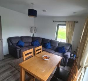 a living room with a couch and a table at Double room with ensuite in Milltown Malbay