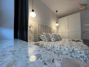 a bedroom with a bed and two pendant lights at Apartament Olimpia in Lębork
