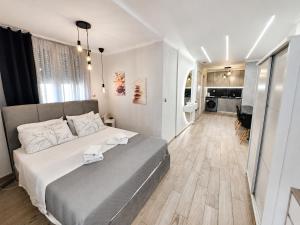 a bedroom with a large bed and a kitchen at Adriana Luxury Studio in Kastoria