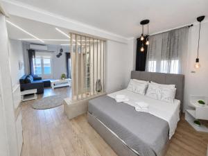 a bedroom with a large bed and a living room at Adriana Luxury Studio in Kastoria