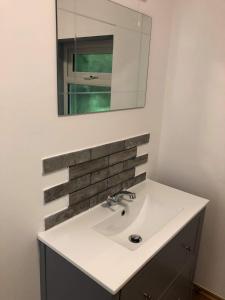 a bathroom with a sink and a mirror at Our Wendy House in Holsworthy