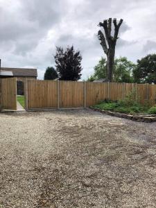 a wooden fence in a yard with a tree at Our Wendy House in Holsworthy