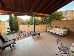 a patio with a couch and a table and chairs at El encanto de un pueblo in Grajal de Campos