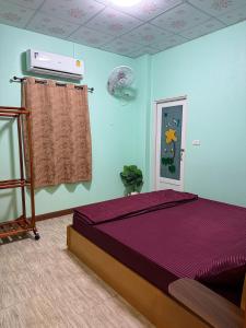 a bedroom with a purple bed in a room at เพียงภูโฮมสเตย์ in Sattahip +8 photos
