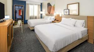a hotel room with two beds and a desk at Spark By Hilton Owen Sound in Owen Sound