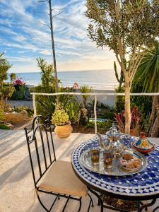 a table and chairs with a plate of food on it at Villa Jardin De l'Ocean in Aourir +133 photos
