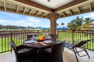 a table on a balcony with a view of the ocean at Halii Kai 11D in Waikoloa