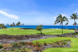 a golf course with palm trees and the ocean at Halii Kai 11D in Waikoloa +50 photos