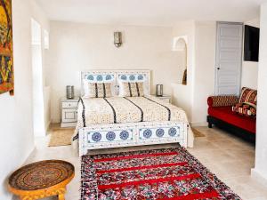a bedroom with a bed and a red couch at Villa Jardin De l'Ocean in Aourir
