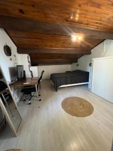 a room with a bed and a desk and a deskablish at "Villa du Pin" idéalement situé Ruoms à pieds, voie verte in Ruoms