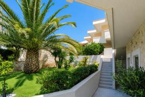 a view of the courtyard of a house with a palm tree at Veneto Sea View Apartments in Stalís