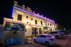 two cars parked in front of a hotel at night at فندق هوتيلتن HotelTen in Riyadh