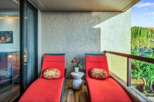 a balcony with red cushions and a toilet on it at Kona Pacific A306 in Kailua-Kona