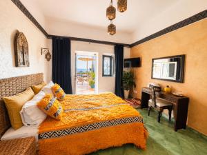 a bedroom with a bed and a desk and a table at Villa Jardin De l'Ocean in Aourir