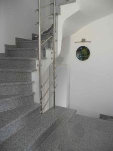 a staircase with a metal railing next to a white wall at Apartments JP in Jezera