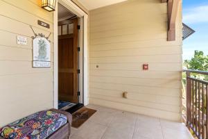 a front door of a house with a bench on a porch at Halii Kai 20F in Waikoloa +50 photos