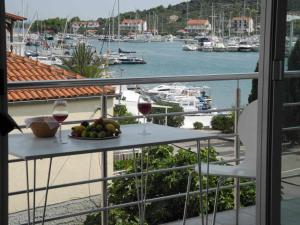 a balcony with a table with two glasses of wine at Apartments JP in Jezera