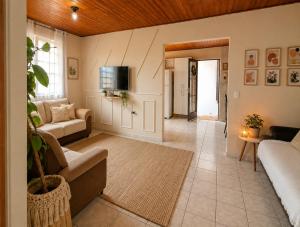 a living room with a couch and a tv at Puxadinho do Sossego in Presidente Epitácio