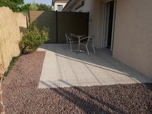 a patio with a table and chairs next to a building at Studios Saint Mau 1 in Saint-Maurice-de-Gourdans